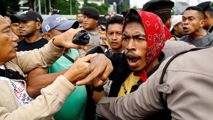 Potret Massa AMSI Demo Tolak Pemakzulan Jokowi Policem officers block pro-government protesters as they approach anti-government protesters holding a rally demanding a fair election, outside the Indonesian parliament in Jakarta, Indonesia, February 12, 2024. REUTERS/KimΒ Kyung-Hoon