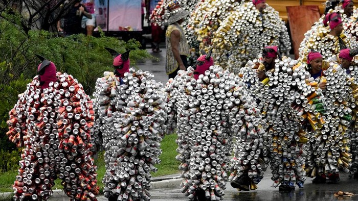 Revelers wearing costumes made from beer and soda cans take part in the 'Bloco da Latinha' street party Carnival parade in Madre de Deus, Brazil, Sunday, Feb. 11, 2024. (AP Photo/Eraldo Peres)