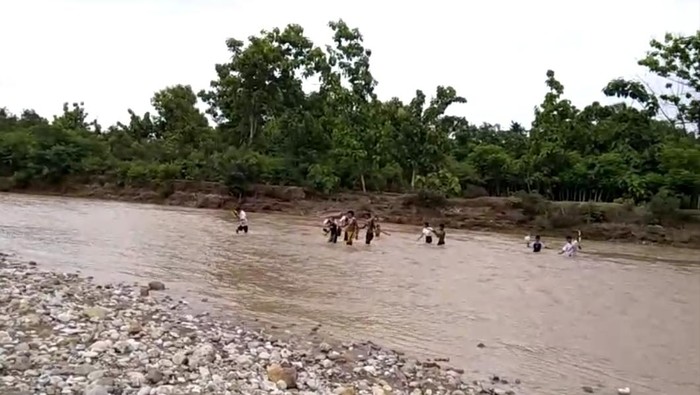 Tangkapan layar puluhan siswa SMPN I Amfoang Barat Daya, Kabupaten Kupang, NTT, saat menerobos banjir di Sungai Kapsali, Senin (12/2/2024). (Istimewa)