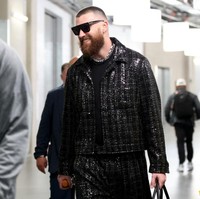 Kekasih Taylor Swift ini tampak mengenakan setelan jaket dan celana baggy berlapis sequin yang memberi tampilan berkilau. Di bawah jaketnya, Travis memakai t-shirt yang juga berwarna hitam. Foto: Steph Chambers/Getty Images