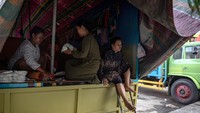 Warga korban banjir beristirahat di dalam truk kosong yang dijadikan tempat pengungsian darurat di jalan utama Pantura Demak-Kudus, Kecamatan Karanganyar, Demak, Jawa Tengah, Senin (12/2/20204).