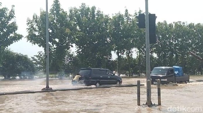 Warga saat mendorong mobil mogok akibat banjir di GT Kertajati, Majalengka