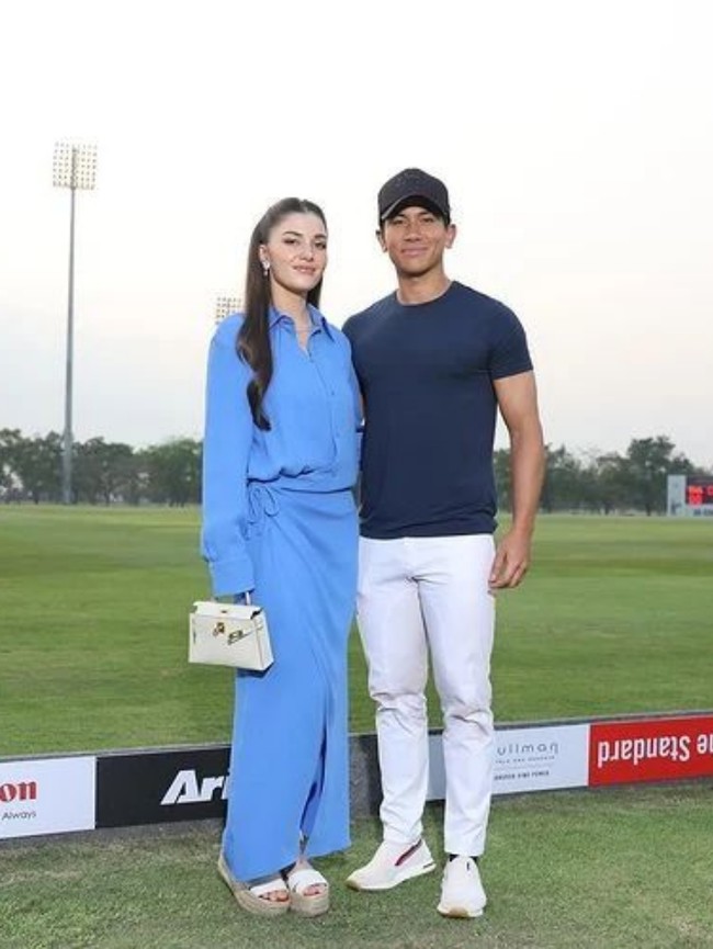 Pangeran Abdul Mateen dan Anisha Rosnah menyempatkan foto bersama di pinggir lapangan. Anisha memilih gaya chic dan simple dengan shirt dress biru dari koleksi Maison Valentino. Dia tampak menenteng tas Hermes Mini Kelly dan melengkapi gayanya dengan sandal espadrilles wedges. Foto: Instagram/@tmski @modxmakeup