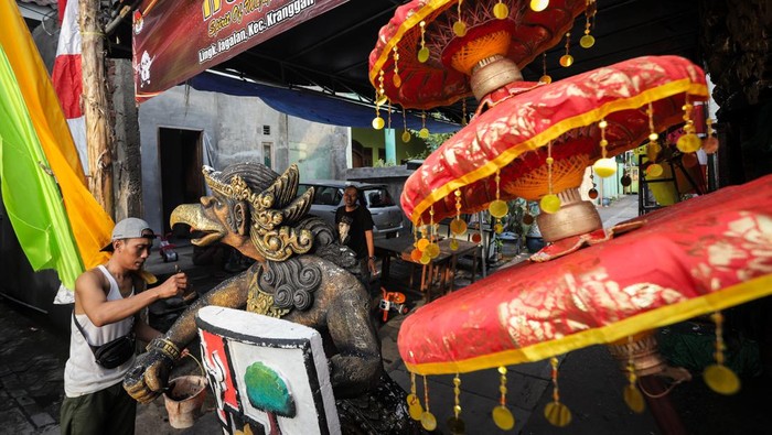 Warga menyelesaikan dekorasi Tempat Pemungutan Suara (TPS) unik untuk pelaksanaan Pemilu 2024 di Jagalan, Mojokerto, Jawa Timur, Selasa (13/2/2024). TPS dengan tema Spirit of Majapahit tersebut untuk meningkatkan partisipasi warga pada Pemilu 14 Februari. ANTARA FOTO/Rizal Hanafi/Spt