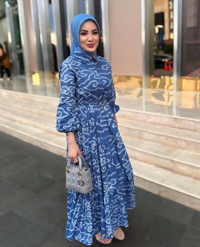 Nindy Ayunda tampak feminin dan anggun memakai dress batik mega mendung. Ia melengkapi penampilan dengan gaya hijab simple menggunakan kerudung biru. Foto: Instagram @nindyayunda