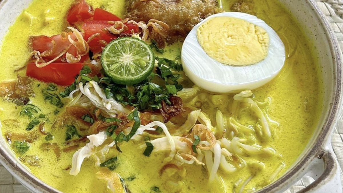 Semangkuk bihun soto Medan dengan kuah santan kental, lengkap dengan potongan ayam dan taburan bawang goreng.