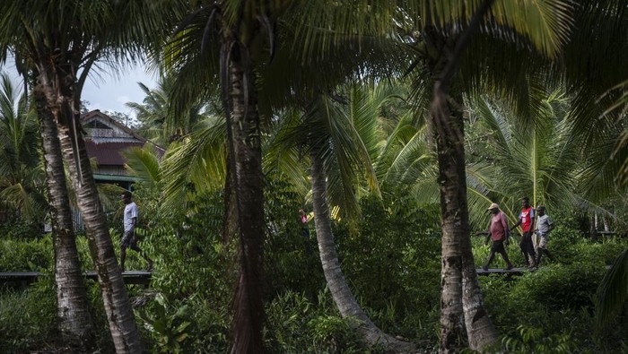 Seorang mama Papua berjalan bersama anaknya di Kampung Saw, Distrik Agats, Kabupaten Asmat, Papua Selatan, Selasa (13/2/2024). Kabupaten Asmat memiliki 224 kampung atau setara tingkat kelurahan yang berdiri di atas tanah berlumpur dan rawa serta memiliki sarana jalan dari papan kayu. ANTARA FOTO/Aprillio Akbar/Spt.