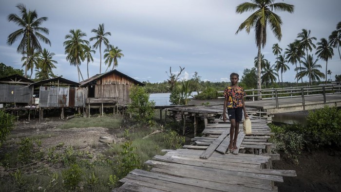 Seorang mama Papua berjalan bersama anaknya di Kampung Saw, Distrik Agats, Kabupaten Asmat, Papua Selatan, Selasa (13/2/2024). Kabupaten Asmat memiliki 224 kampung atau setara tingkat kelurahan yang berdiri di atas tanah berlumpur dan rawa serta memiliki sarana jalan dari papan kayu. ANTARA FOTO/Aprillio Akbar/Spt.
