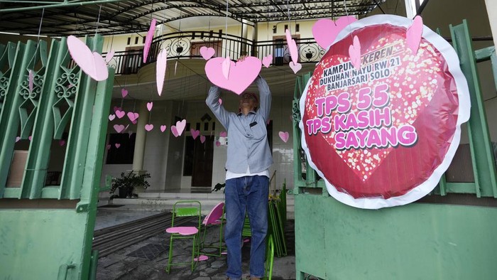 Kreatif! TPS di Solo Ini Bertema Valentine A man decorates a heart symbol for Valentine's Day at a polling station in Solo, Central Java, Indonesia, Tuesday, Feb. 13, 2024. Indonesia, the world's third-largest democracy, will open its polls on Wednesday to nearly 205 million eligible voters in presidential and legislative elections, the fifth since Southeast Asia's largest economy began democratic reforms in 1998.(AP Photo/Achmad Ibrahim)