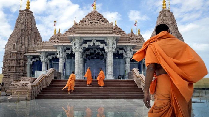 Hindu monks walk down the stairs of the first stone-built Hindu temple in Abu Mureikha, 40 kms, 25 miles, northeast of Abu Dhabi, United Arab Emirates, Monday, Feb. 12, 2024. The soon-to-open BAPS Hindu Mandir signals just how far the United Arab Emirates has come in acknowledging the different faiths of its expatriate community, long dominated by Indians who power life across its construction sites and boardrooms. (AP Photo/Kamran Jebreili)