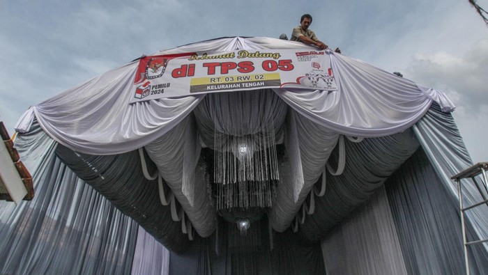 Petugas menyelesaikan dekorasi Tempat Pemungutan Suara (TPS) unik untuk pelaksanaan Pemilu 2024 di Kampung Tengah, Cibinong, Kabupaten Bogor, Jawa Barat, Selasa (13/2/2024). TPS dengan tema Nyoblos di hajatan pernikahan tersebut untuk meningkatkan partisipasi pemilih pada Pemilu 14 Februari 2024. ANTARA FOTO/Yulius Satria Wijaya/Spt.