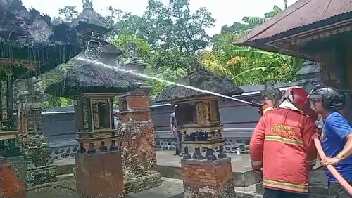 Petugas Damkar Klungkung melakukan penanganan kebakaran Pura Paibon Pasek Gelgel Akah, Selasa (13/2/2024).