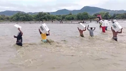 Petugas menerobos banjir di Kali Bonpo, Kecamatan Amfoang Barat Laut, Kabupaten Kupang, NTT, untuk menyeberangkan logistik pemilu.