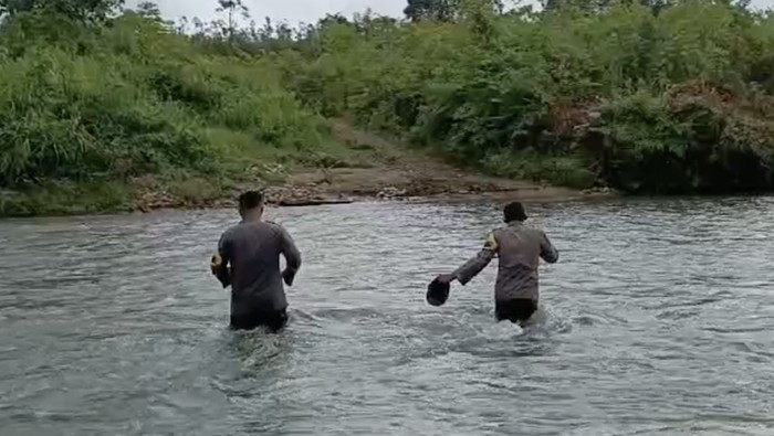 Petugas menyusuri hutan dan 2 sungai saat mengawal distribusi logistik Pemilu di Desa Nafrua. Dokumen Istimewa