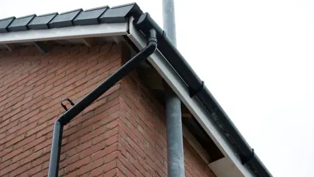 Tiang lampu jalan menembus pinggiran atap rumah di Inggris