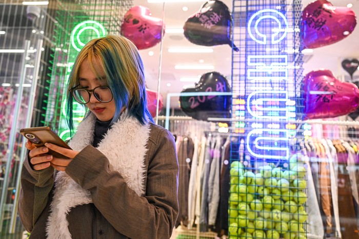 This photo taken on February 2, 2024 shows user Wang Xiuting chatting with her virtual boyfriend on Wantalk - an artificial intelligence chatbot created by Chinese tech company Baidu, on her phone at a shopping mall in Beijing. Twenty-five-year-old Chinese office worker Tufei says her boyfriend has everything she could ask for in a romantic partner: hes kind, empathetic, and sometimes they talk for hours. Except he isnt real. (Photo by Jade GAO / AFP) / To go with CHINA-INTERNET-AI-ROMANCE, FOCUS by Ludovic Ehret and Qian Ye