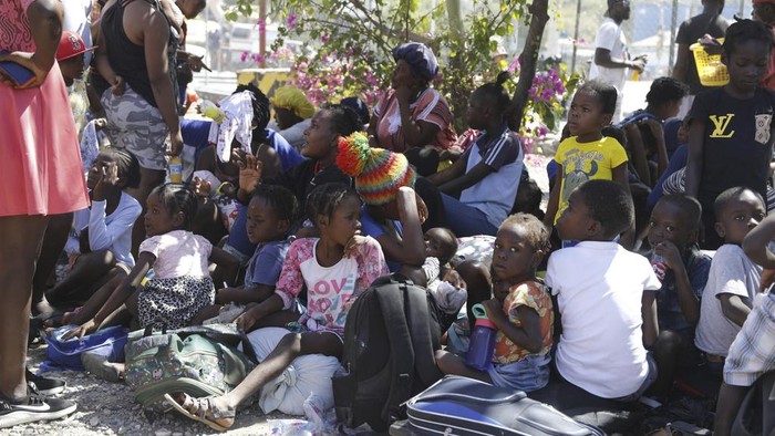 Children and their guardians gather outside a police station after they fled their homes in Cite Soleil due to gang violence, in Port-au-Prince, Haiti, Monday, Feb. 12, 2024. (AP Photo/Odelyn Joseph)
