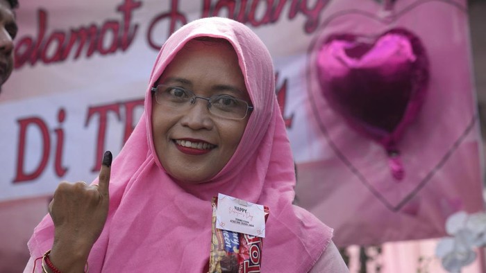 10 Potret Dekorasi TPS Unik, Tema Nikahan hingga Nuansa Jepang A woman shows her inked finger marking that she has already voted during the election at a Valentine's Day-themed polling station in Solo, Central Java, Indonesia, Wednesday, Feb. 14, 2024. Millions of Indonesians were choosing a new president Wednesday as the world's third-largest democracy aspires to become a global economic powerhouse just over 25 years since emerging from a brutal authoritarian era. (AP Photo/Achmad Ibrahim)