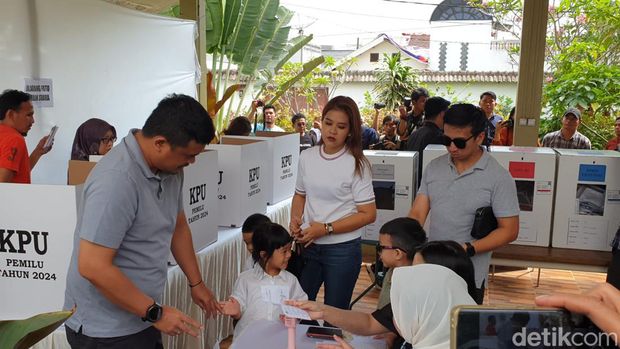 Bobby dan Kahiyang ketika menggunakan hak pilih di TPS. (Goklas Wisely/detikSumut)
