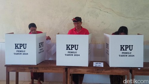 Bupati Karangasem I Gede Dana bersama dengan keluarganya saat melakukan pencoblosan di TPS 27, SDN 7 Datah, Banjar Dinas Lebah, Desa Datah, Kecamatan Abang, Karangasem Rabu (14/2/2024). (I Wayan Selamat Juniasa)