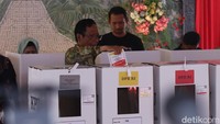 Mahfud memasukkan surat suara ke kotak suara usai melakukan pencoblosan.