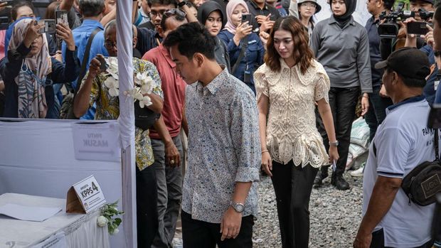 SOLO CITY, INDONESIA - FEBRUARY 14:  Vice presidential candidate Gibran Rakabuming Raka, Indonesian President Joko Widodo's eldest son and current Surakarta City mayor, and his wife Selvi Ananda arrive at a polling station during the Indonesian presidential election on February 14, 2024 in Solo City, Indonesia. Indonesia headed to the polls to vote in presidential elections on February 14. (Photo by Ulet Ifansasti/Getty Images)