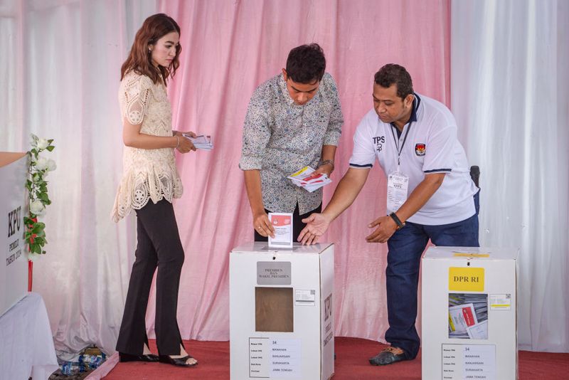 SOLO CITY, INDONESIA - FEBRUARY 14:  Vice presidential candidate Gibran Rakabuming Raka, Indonesian President Joko Widodo's eldest son and current Surakarta City mayor, and his wife Selvi Ananda arrive at a polling station during the Indonesian presidential election on February 14, 2024 in Solo City, Indonesia. Indonesia headed to the polls to vote in presidential elections on February 14. (Photo by Ulet Ifansasti/Getty Images)