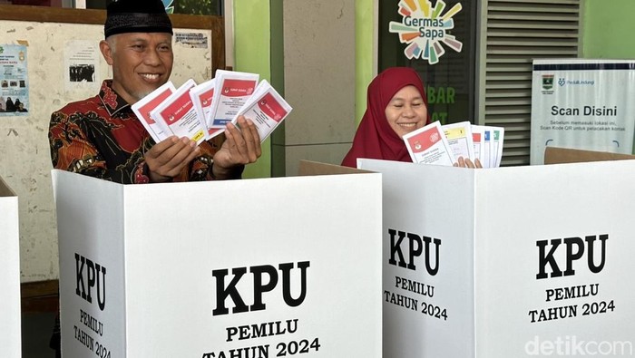 Gubernur Sumbar, Mahyeldi dan istri menunjukkan surat suara sebelum dicoblos di bilik suara TPS 12, Kelurahan Jati Baru, Kota Padang. (Jeka Kampai/detikSumut)