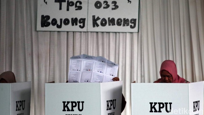 Hujan mengiringi pemilihan umum di Bojong Koneng, Kabupaten Bogor, Jawa Barat,  Rabu (14/2/2024). Meski begitu, warga tetap bersemangat melakukan pencoblosan.