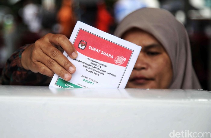Hujan mengiringi pemilihan umum di Bojong Koneng, Kabupaten Bogor, Jawa Barat,  Rabu (14/2/2024). Meski begitu, warga tetap bersemangat melakukan pencoblosan.