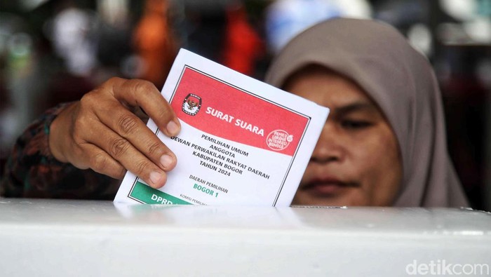 Hujan mengiringi pemilihan umum di Bojong Koneng, Kabupaten Bogor, Jawa Barat,  Rabu (14/2/2024). Meski begitu, warga tetap bersemangat melakukan pencoblosan.