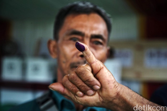 Hujan mengiringi pemilihan umum di Bojong Koneng, Kabupaten Bogor, Jawa Barat,  Rabu (14/2/2024). Meski begitu, warga tetap bersemangat melakukan pencoblosan.
