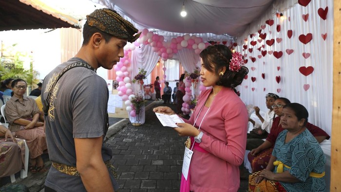 A woman casts her ballot at a Valentine's Day themed polling station during the presidential and legislative election in Denpasar, Bali, Indonesia ,on Wednesday, Feb. 14, 2024. (AP Photo/Firdia Lisnawati)