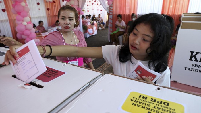 A woman casts her ballot at a Valentine's Day themed polling station during the presidential and legislative election in Denpasar, Bali, Indonesia ,on Wednesday, Feb. 14, 2024. (AP Photo/Firdia Lisnawati)