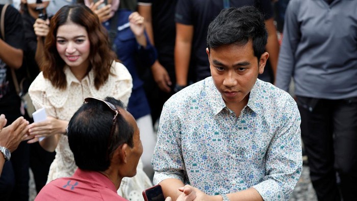 Vice President candidate Gibran Rakabuming Raka, who is the eldest son of Indonesian President Joko Widodo and current Mayor of Surakarta, along with his wife Selvi Ananda, waves after casting his vote during the general election, in Surakarta, Central Java province, Indonesia, February 14, 2024. REUTERS/Willy Kurniawan