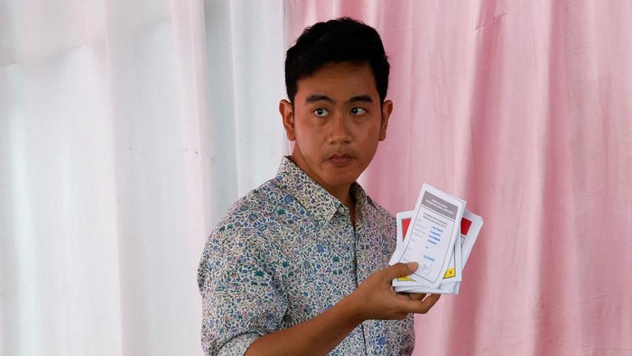 Vice President candidate Gibran Rakabuming Raka, who is the eldest son of Indonesian President Joko Widodo and current Mayor of Surakarta, along with his wife Selvi Ananda, waves after casting his vote during the general election, in Surakarta, Central Java province, Indonesia, February 14, 2024. REUTERS/Willy Kurniawan