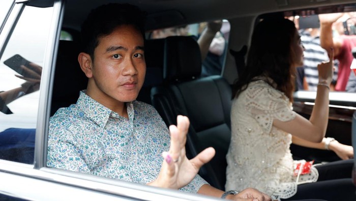 Vice President candidate Gibran Rakabuming Raka, who is the eldest son of Indonesian President Joko Widodo and current Mayor of Surakarta, along with his wife Selvi Ananda, waves after casting his vote during the general election, in Surakarta, Central Java province, Indonesia, February 14, 2024. REUTERS/Willy Kurniawan