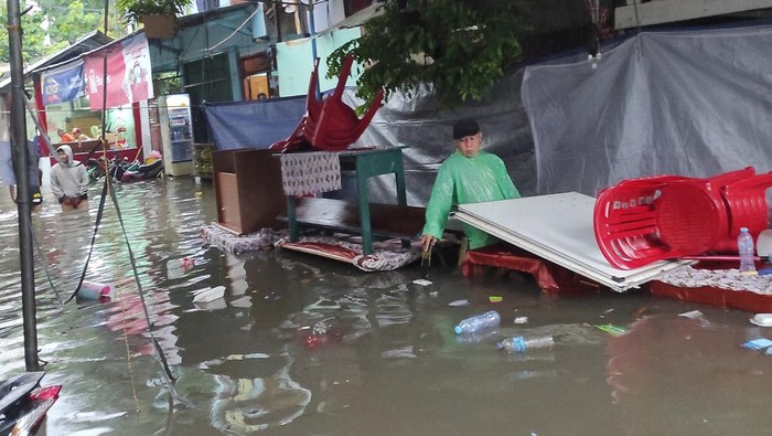 People walk through flood water on the day of general elections, in Jakarta, Indonesia, February 14, 2024, in this picture obtained from social media. Adi Utama Putra/via REUTERS  THIS IMAGE HAS BEEN SUPPLIED BY A THIRD PARTY. MANDATORY CREDIT. NO RESALES. NO ARCHIVES.