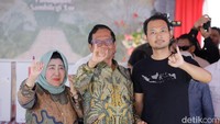 Mahfud bersama istri dan anaknya menunjukkan jari kelingking yang telah dicelupkan ke tinta.