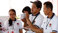 Petugas menghitung jumlah surat suara sebelum pemungutan suara dimulai.