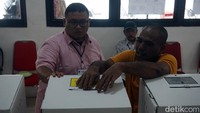 Petugas KKPS di TPS 901 sedang membantu warga binaan yang memasukkan surat suara ke dalam kotak suara.