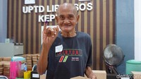 Senyum warga binaan Liponsos Keputih Surabaya setelah menyalurkan hak pilihnya di TPS 54 yang berada di UPTD Liponsos Keputih.