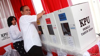 Budi Arie dan istri memasukkan surat suara ke dalam kotak suara usai melakukan pencoblosan.