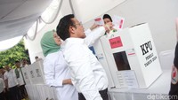 Bersama istrinya, Muhaimin memasukan kertas suara ke dalam kotak suara.