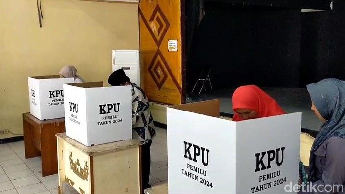 Momen Walikota Bandar Lampung Eva Dwiana menukar surat suara yang dibawa oleh ajudannya