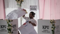 Seorang warga membuka surat suara yang ia terima untuk menyalurkan hak pilihnya dalam pemilu 2024 kali ini.