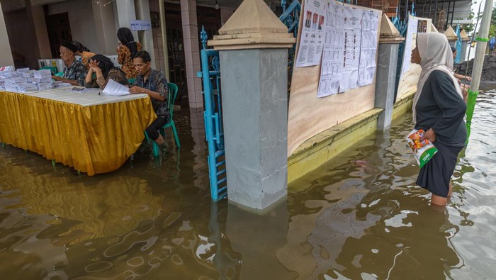 Pelaksanaan Pemilu 2024 saat banjir di Demak Warga menembus banjir seusai menggunakan hak pilihnya pada Pemilu 2024 di Tempat Pemungutan Suara (TPS) 02 yang terkepung banjir di Desa Ngelowetan , Kecamatan Mijen, Kabupaten Demak, Jawa Tengah, Rabu (14/2/2024). Sejumlah TPS di Kecamatan Mijen terpaksa dipindahkan ke area yang lebih aman dari genangan banjir pada hari Pemilu 2024 karena adanya banjir di luar prediksi pada Selasa (13/2) dini hari limpasan aliran banjir Kecamatan Karanganyar, Kabupaten Demak. ANTARA FOTO/Aji Styawan/aww.