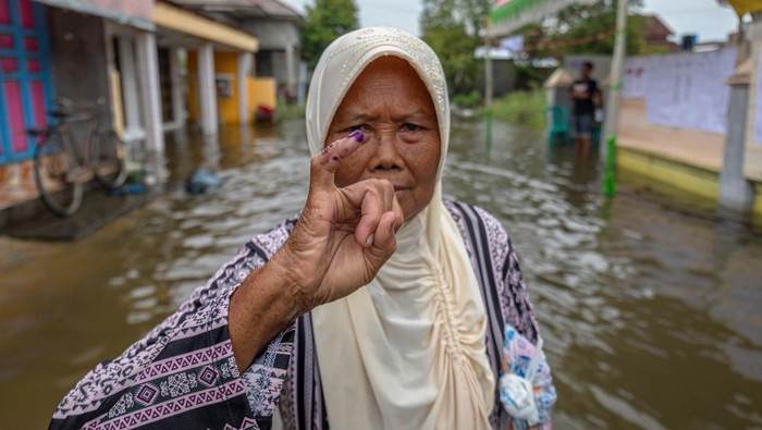 Pelaksanaan Pemilu 2024 saat banjir di Demak Warga menembus banjir seusai menggunakan hak pilihnya pada Pemilu 2024 di Tempat Pemungutan Suara (TPS) 02 yang terkepung banjir di Desa Ngelowetan , Kecamatan Mijen, Kabupaten Demak, Jawa Tengah, Rabu (14/2/2024). Sejumlah TPS di Kecamatan Mijen terpaksa dipindahkan ke area yang lebih aman dari genangan banjir pada hari Pemilu 2024 karena adanya banjir di luar prediksi pada Selasa (13/2) dini hari limpasan aliran banjir Kecamatan Karanganyar, Kabupaten Demak. ANTARA FOTO/Aji Styawan/aww.