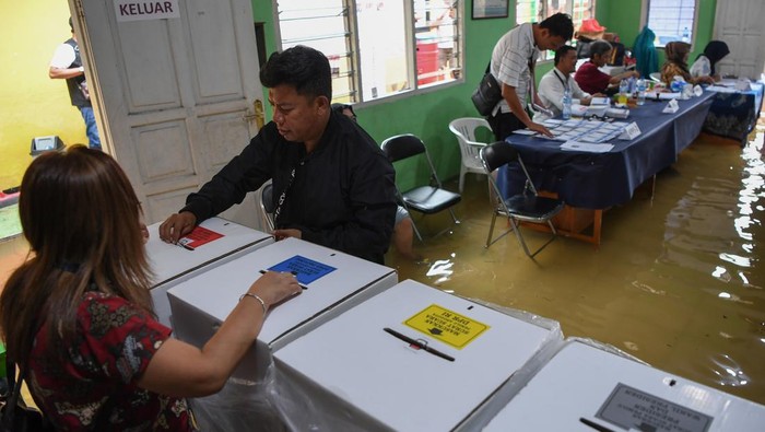 Pemungutan suara pemilu di TPS terdampak banjir Warga memasukan surat suara Pemilu 2024 ke kotak suara saat banjir yang menggenang di TPS 028 Jelambar, Jakarta Barat, Rabu (14/2/2024). TPS tersebut tetap melaksanakan pesta demokrasi lima tahunan untuk memilih presiden dan wakil presiden, DPR, DPRD Provinsi, DPRD Kabupaten/Kota serta DPD meskipun banjir akibat meluapnya Kali Sekretaris. ANTARA FOTO/Wahyu Putro A/tom.