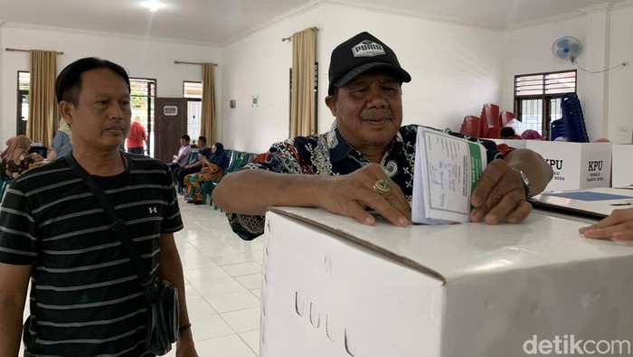 Penyandang tuna netra saat memasukkan kertas suara ke kotak TPS di Medan